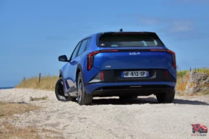 Kia EV4 Air Bleu Fusion vue de trois quart arrière sur plage bord de mer