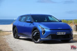 Kia EV4 Air Bleu Fusion vue de trois quart avant sur plage bord de mer