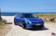 Kia EV4 Air Bleu Fusion vue de trois quart avant sur plage bord de mer