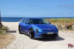 Kia EV4 Air Bleu Fusion vue de trois quart avant sur plage bord de mer
